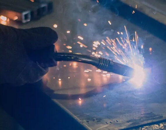 Manufacturing team are cutting a metal sheet witا welding machine.